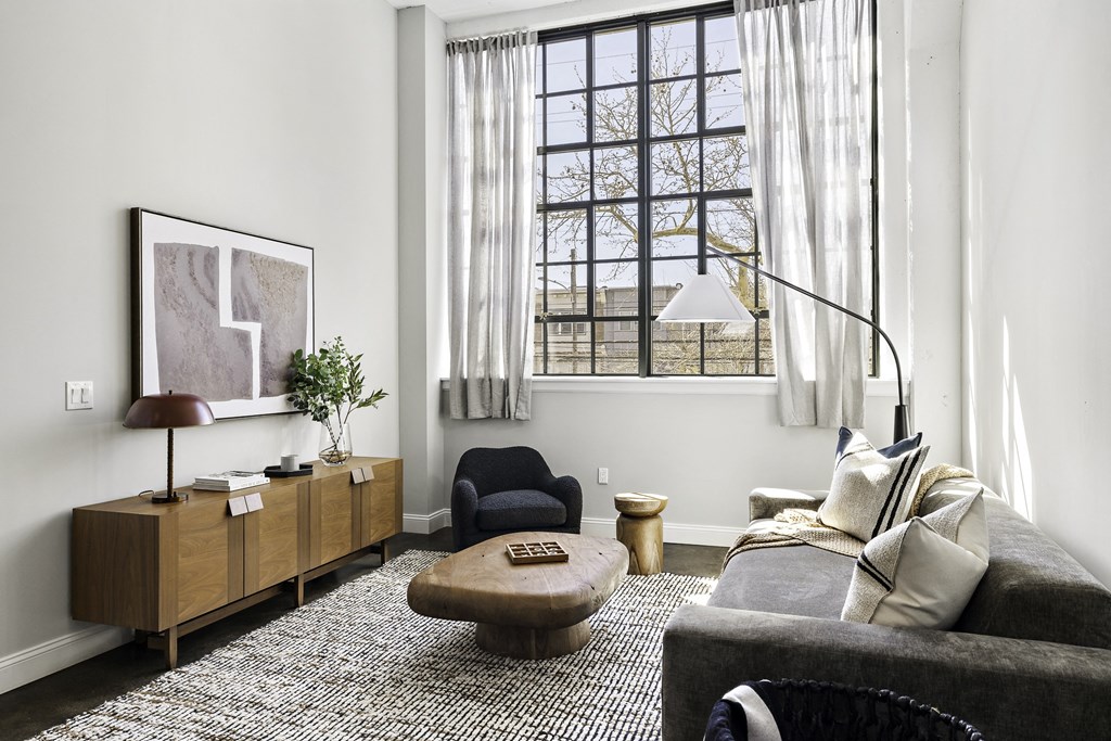 a living room with a couch and a chair and a window