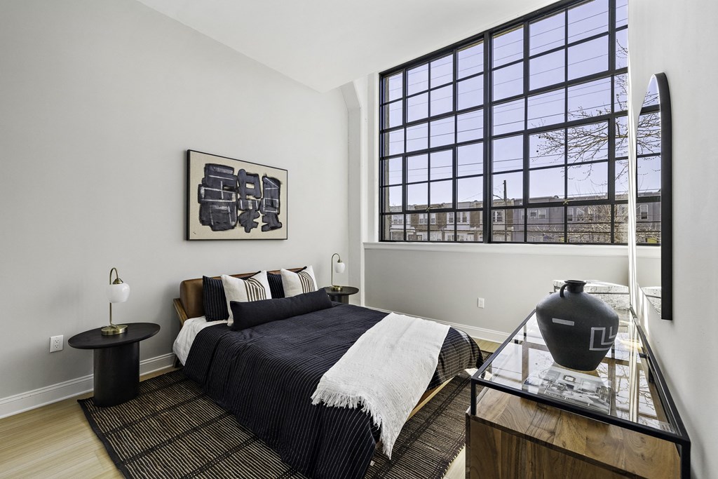 a bedroom with a bed and a large window