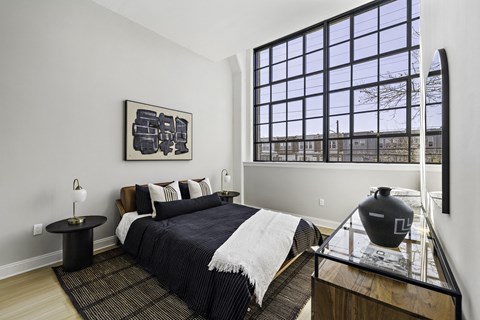 a bedroom with a bed and a large window