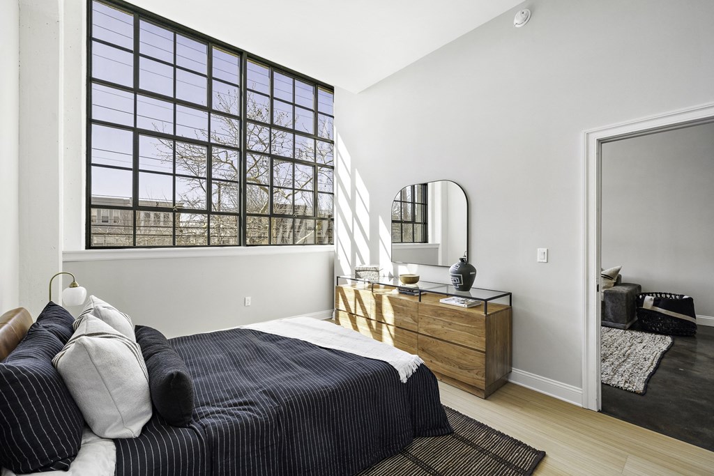 a bedroom with a bed and a large window