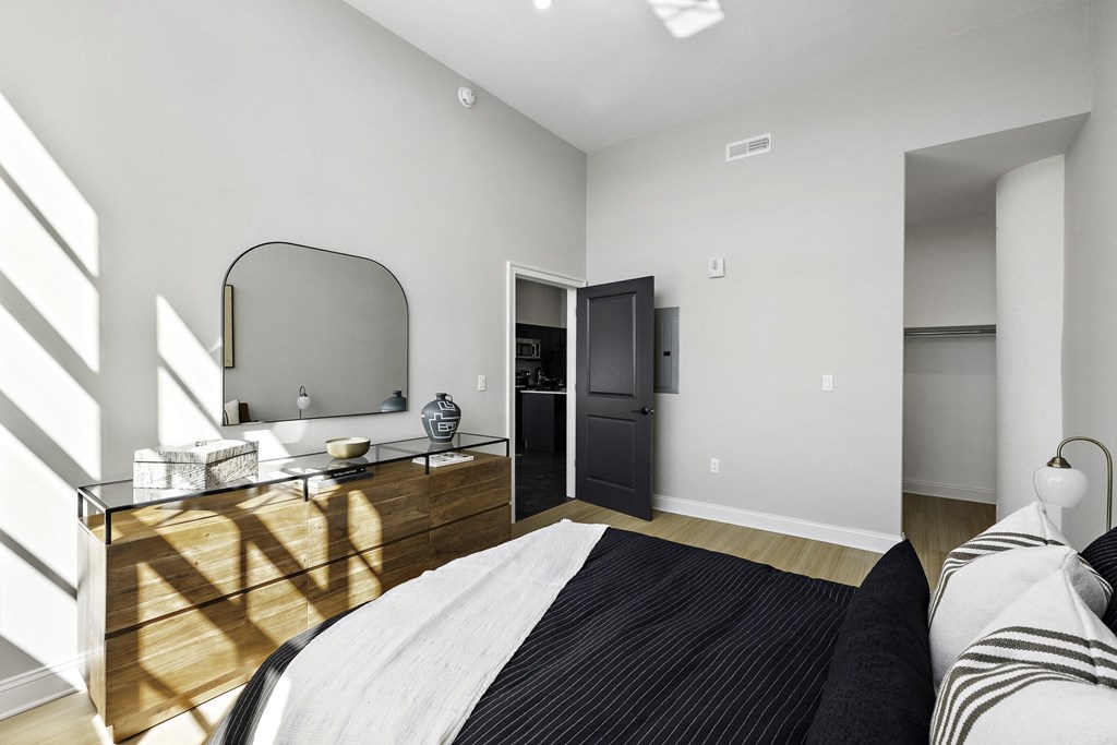 a bedroom with a bed and a dresser with a mirror