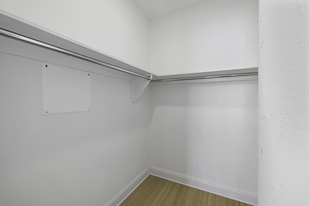 the living room of an empty apartment with white walls and a wood floor