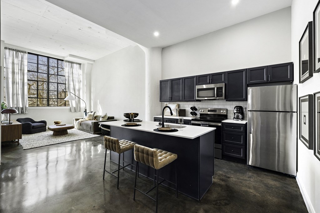 a kitchen with a center island and a stainless steel refrigerator