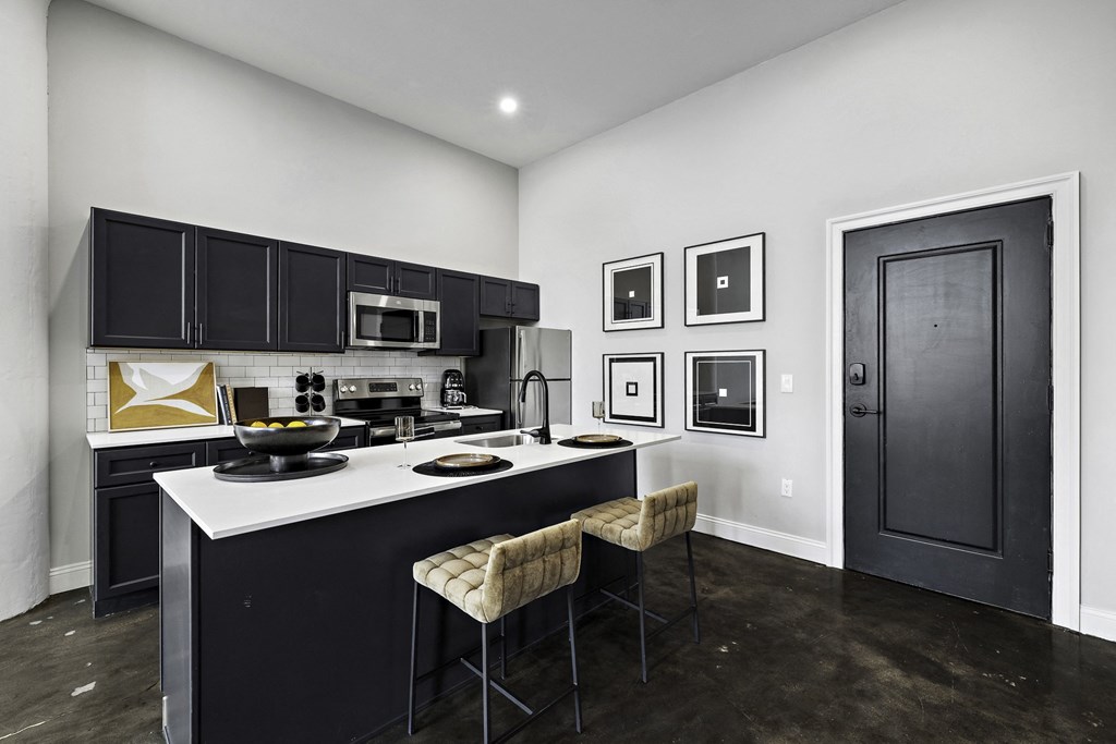 a kitchen with black cabinets and a white counter top
