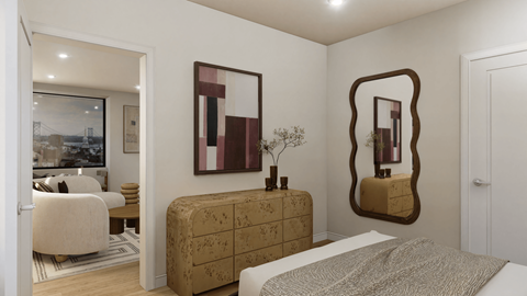 A bedroom with a bed, a chair, a dresser, and a mirror.