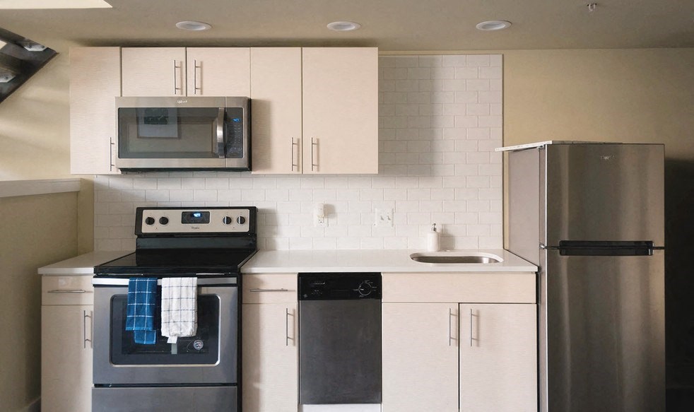 a kitchen with stainless steel appliances and white cabinets