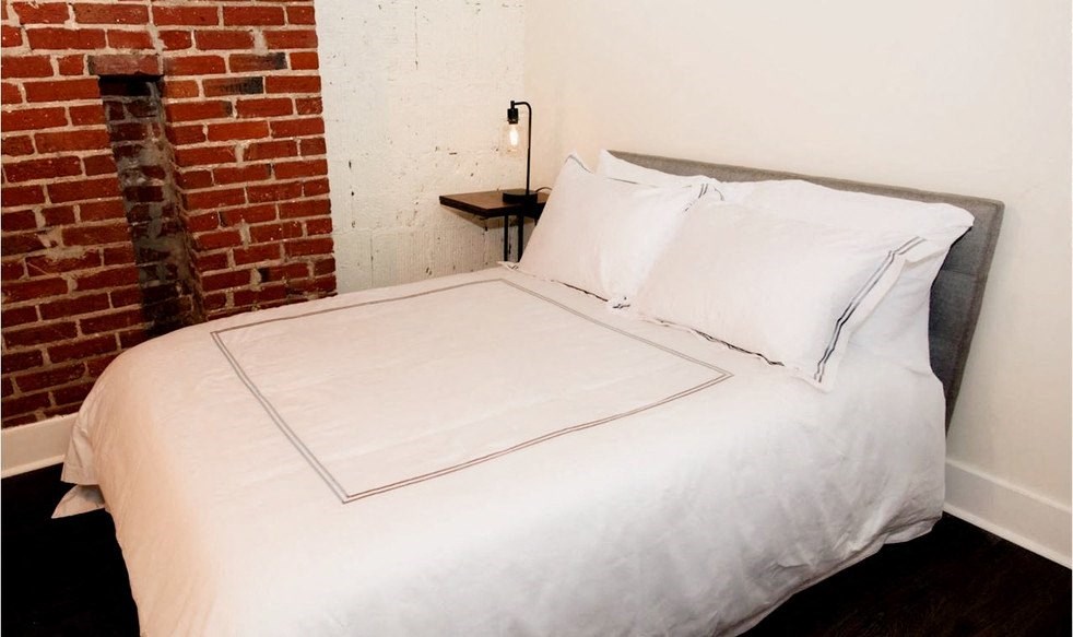 a bedroom with a bed and a window with orange lights