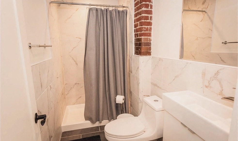 a bathroom with a shower curtain and a toilet and a sink