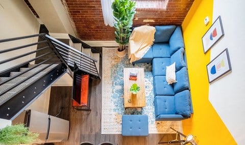 an aerial view of a living room with a blue couch and a yellow wall
