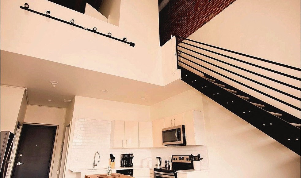 a white kitchen with a microwave and a sink