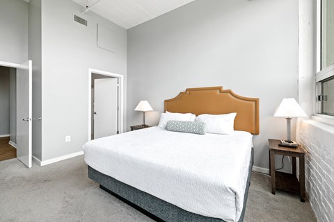 a bedroom with a large bed and a door to a bathroom