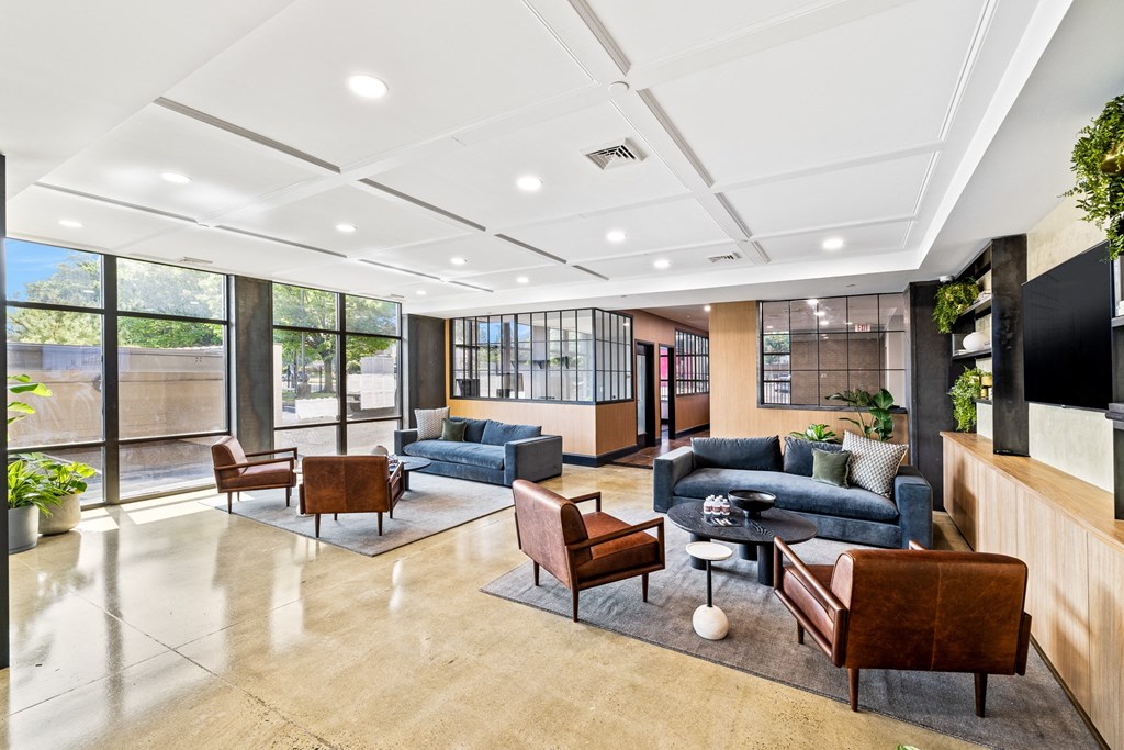 a lobby with couches and chairs and a tv