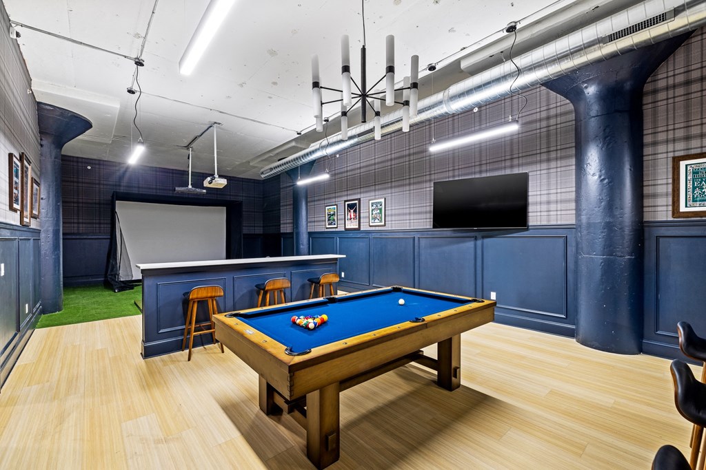 a games room with a pool table and a television
