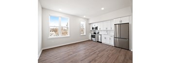 A kitchen with white cabinets and a refrigerator.
