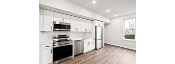 A kitchen with white cabinets and stainless steel appliances.