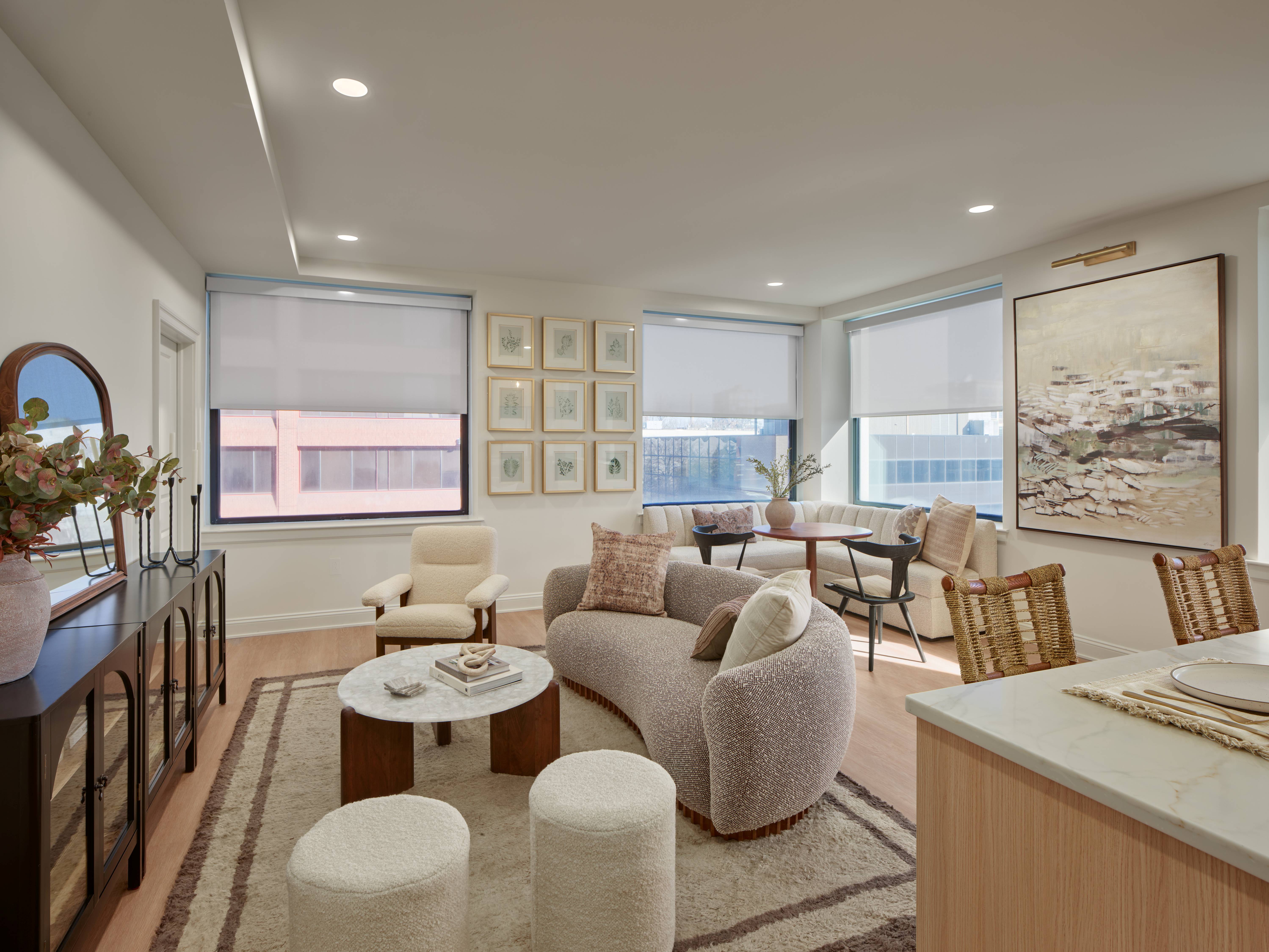 A living room with a large couch, a coffee table, and a painting on the wall.