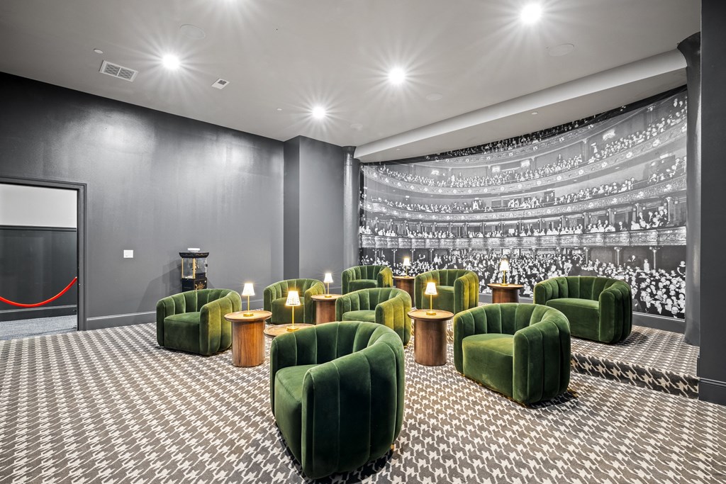 a large theater room with green chairs and a projector screen