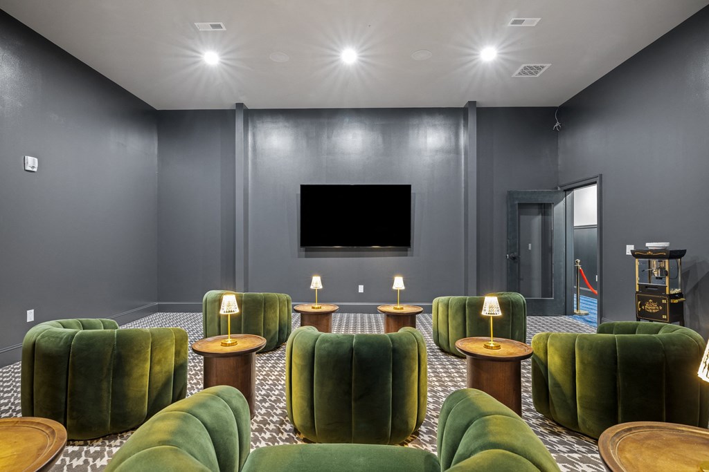 a living room with green chairs and a television