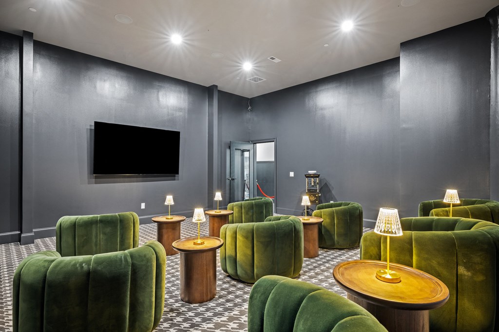 a living room with green chairs and a tv