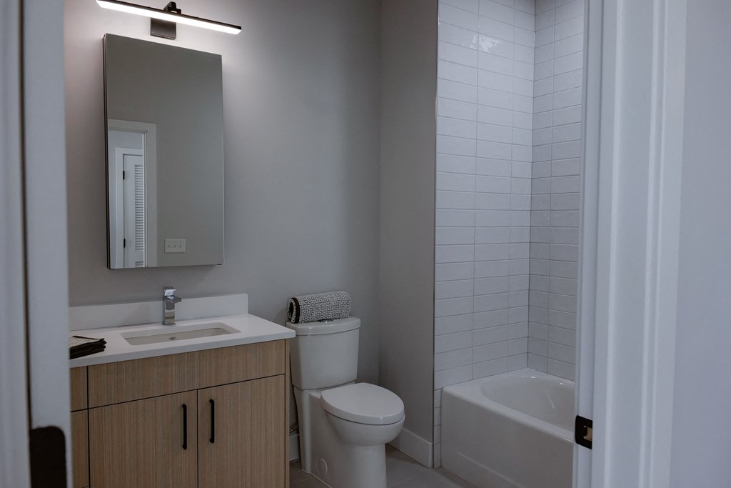 a bathroom with a sink toilet and shower and a mirror