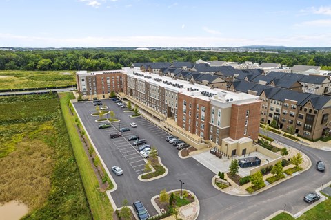 an aerial view of a large apartment building with cars parked in front of it