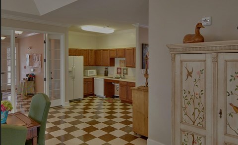 A kitchen with a checkered floor and wooden cabinets.