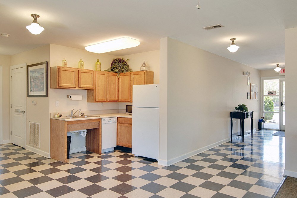 a kitchen with a checkered floor and a refrigerator