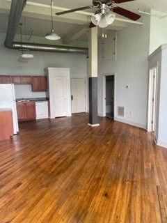 A room with wooden floors and a ceiling fan.