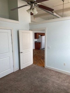A room with a ceiling fan and two doors.