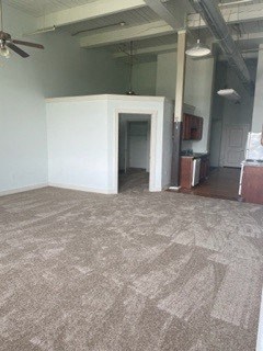 A room with a carpeted floor and a white wall.