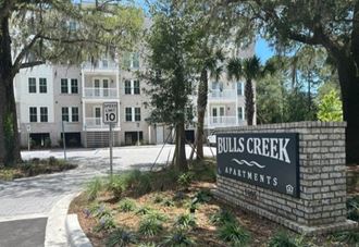 an apartment building with a bulls creek apartments sign in front of it