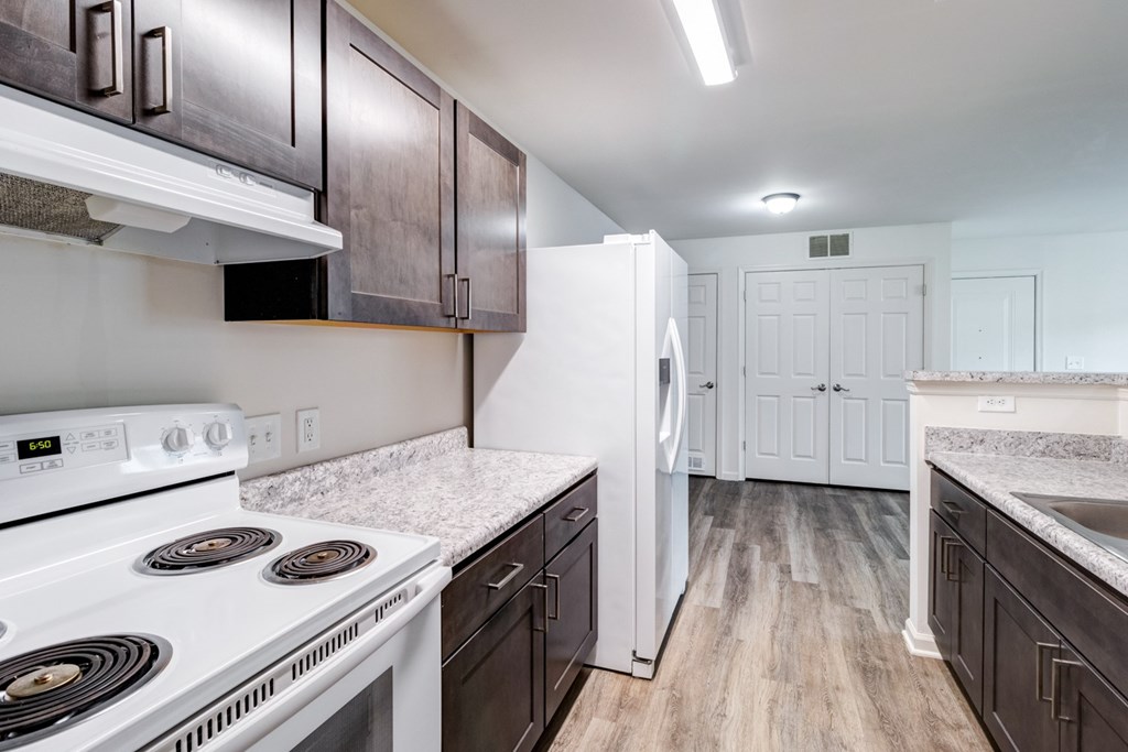 A kitchen with a white stove and white refrigerator. at Ada Park Apartments, Newport News, VA