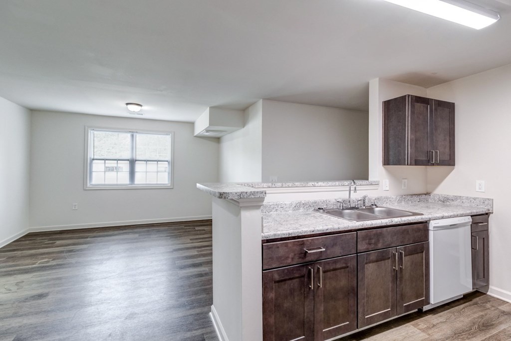 A kitchen with dark wood cabinets and a white countertop. at Ada Park Apartments, Newport News, VA
