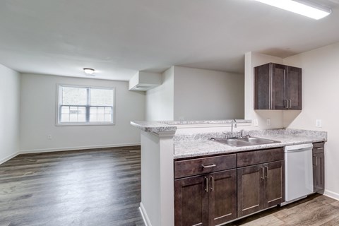 A kitchen with dark wood cabinets and a white countertop.