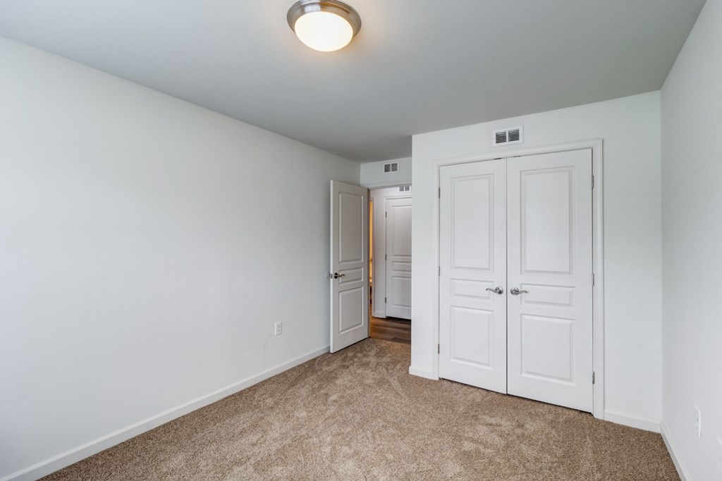 A white door is in a room with carpeting. at Ada Park Apartments, Virginia