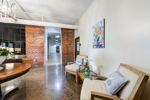 A living room with a couch, a table, and a painting on the wall.