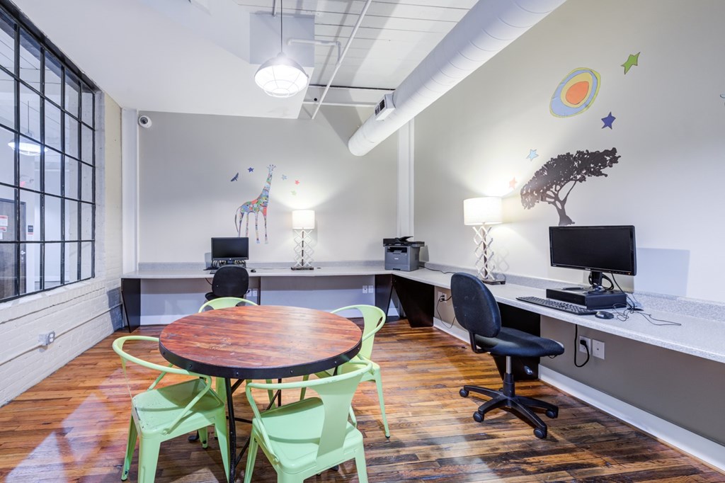 Computer room with a table, chairs and computers.