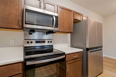 A kitchen with a stainless steel refrigerator and a black oven.