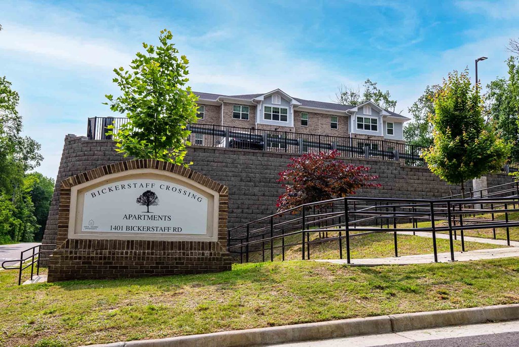 A sign for Bickerstaff Crossing Apartments stands in front of a brick wall. at Bickerstaff Crossing Apartments, Henrico, VA