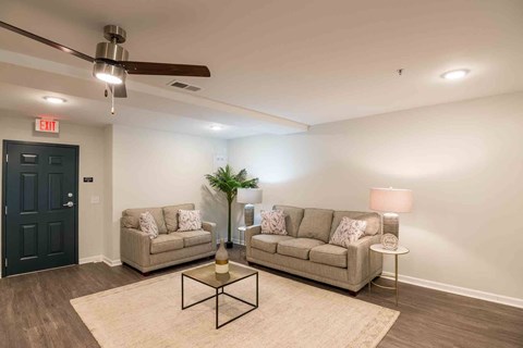 A living room with two couches, a coffee table, and a ceiling fan.