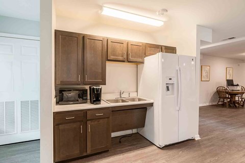 A kitchen with brown cabinets and a white refrigerator.