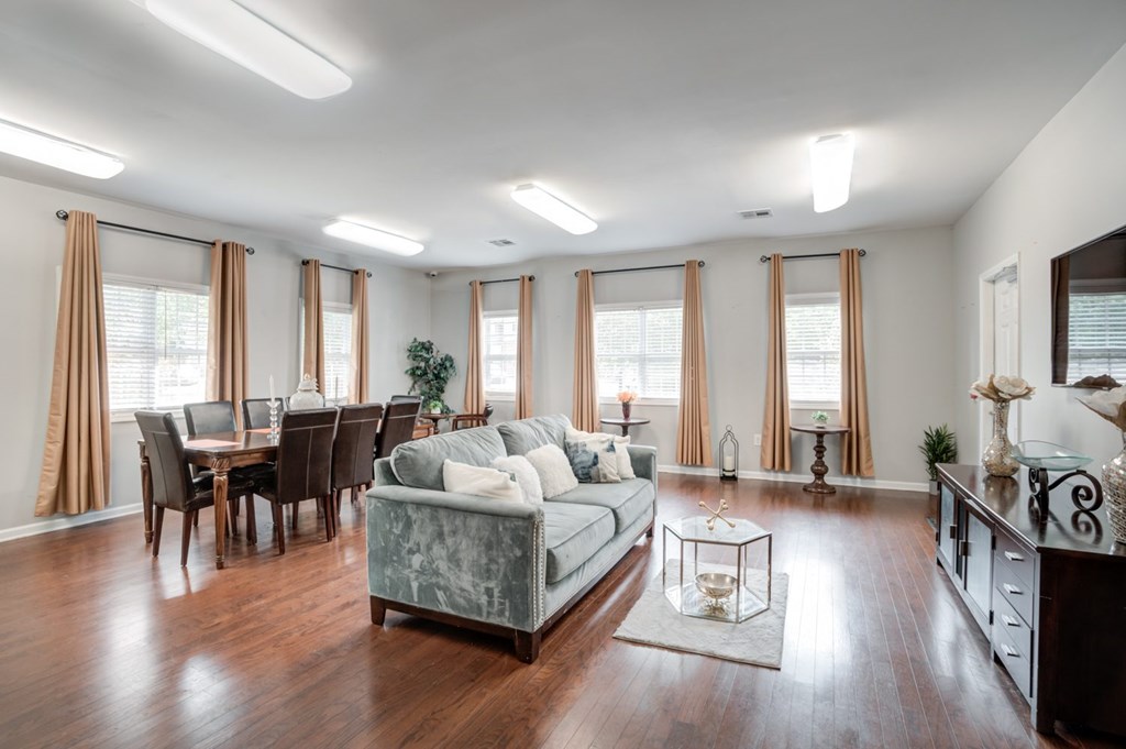A living room with a grey couch and wooden floors.