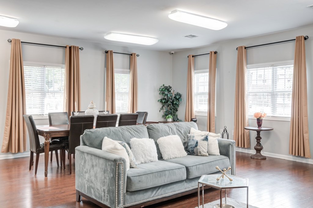 A living room with a grey couch and a glass coffee table.