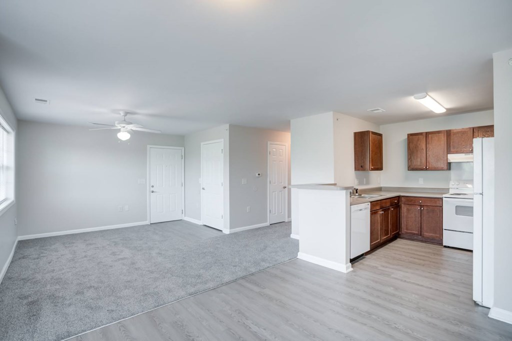 A spacious kitchen with white appliances and wooden cabinets.