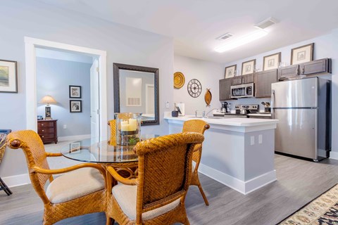 A kitchen with a dining table and chairs.