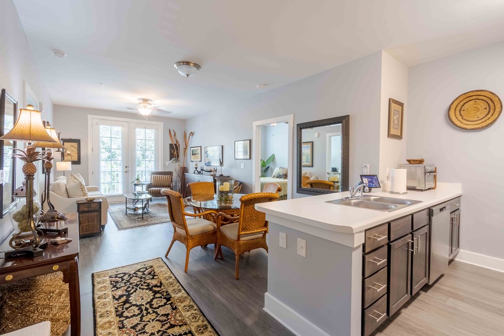 A modern kitchen with a white countertop and wooden chairs. at Bulls Creek, South Carolina, 29414