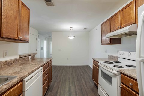 A kitchen with white appliances and wooden cabinets.