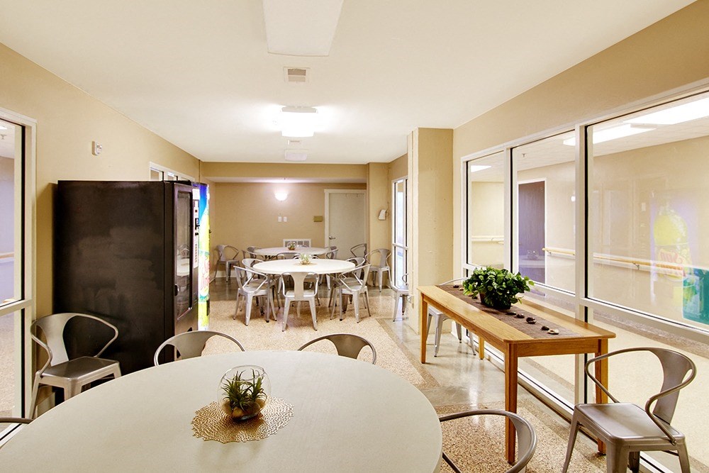 a dining room with tables and chairs and a large window