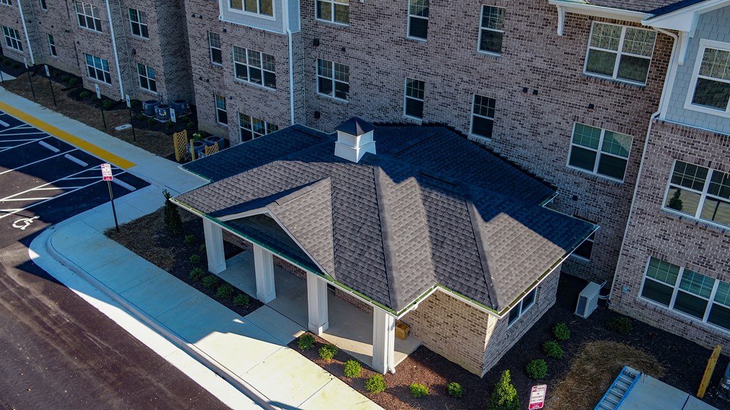 an aerial view of a brick building with a blue roof