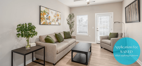 A living room with a couch, a coffee table, and a painting on the wall.
